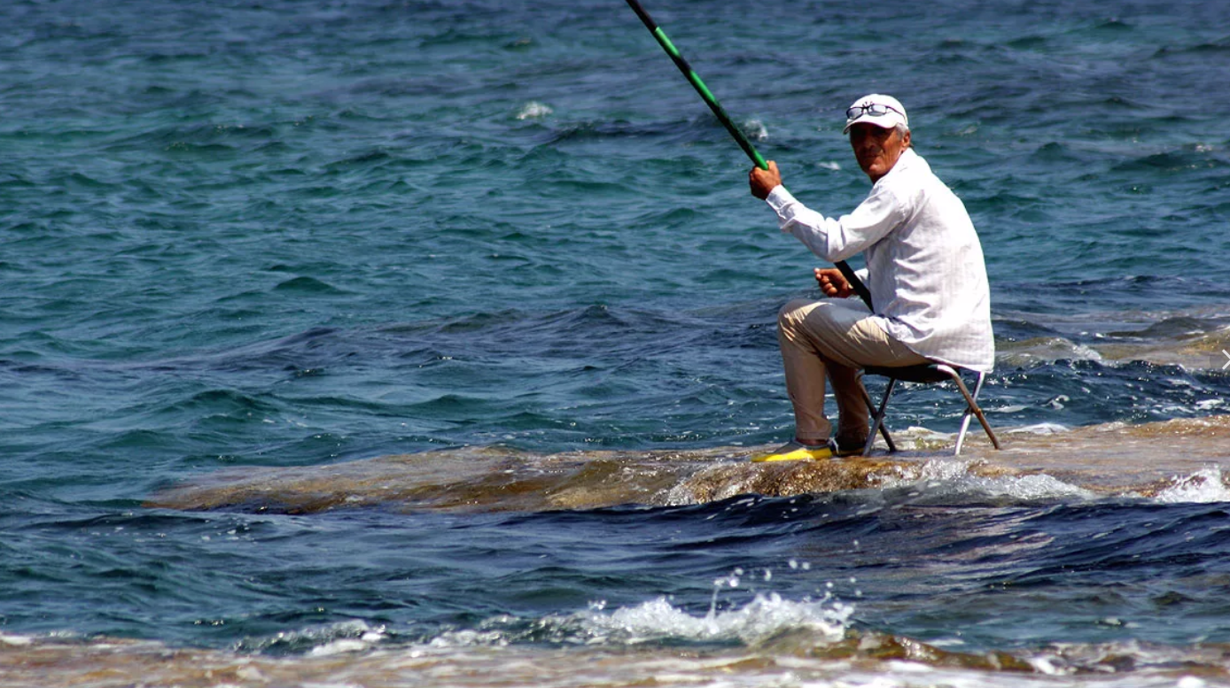 Рыбалка «на море». Человек рыбачит на берегу. Рыбаки в море. Рыболовство в черном море.